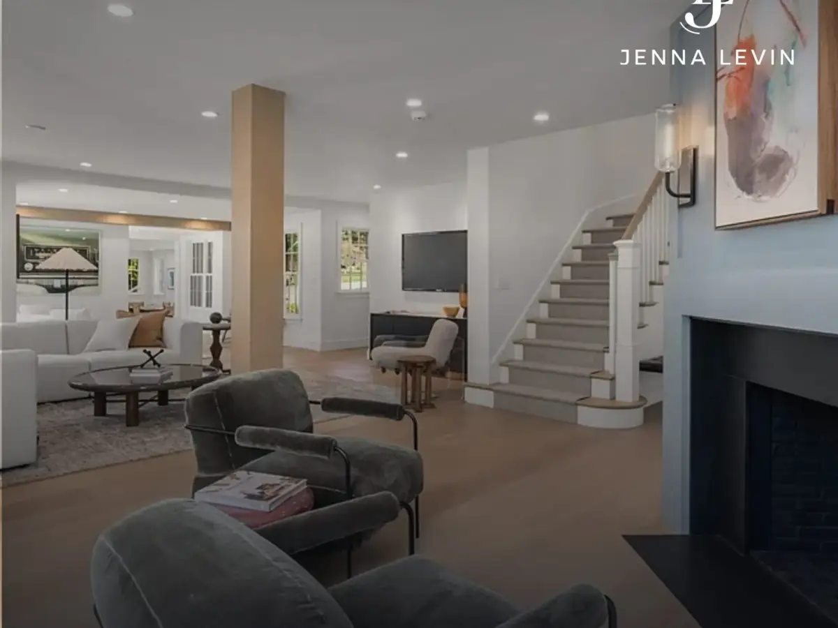 Furnished open-plan living room with a staircase, fireplace, and gray seating.